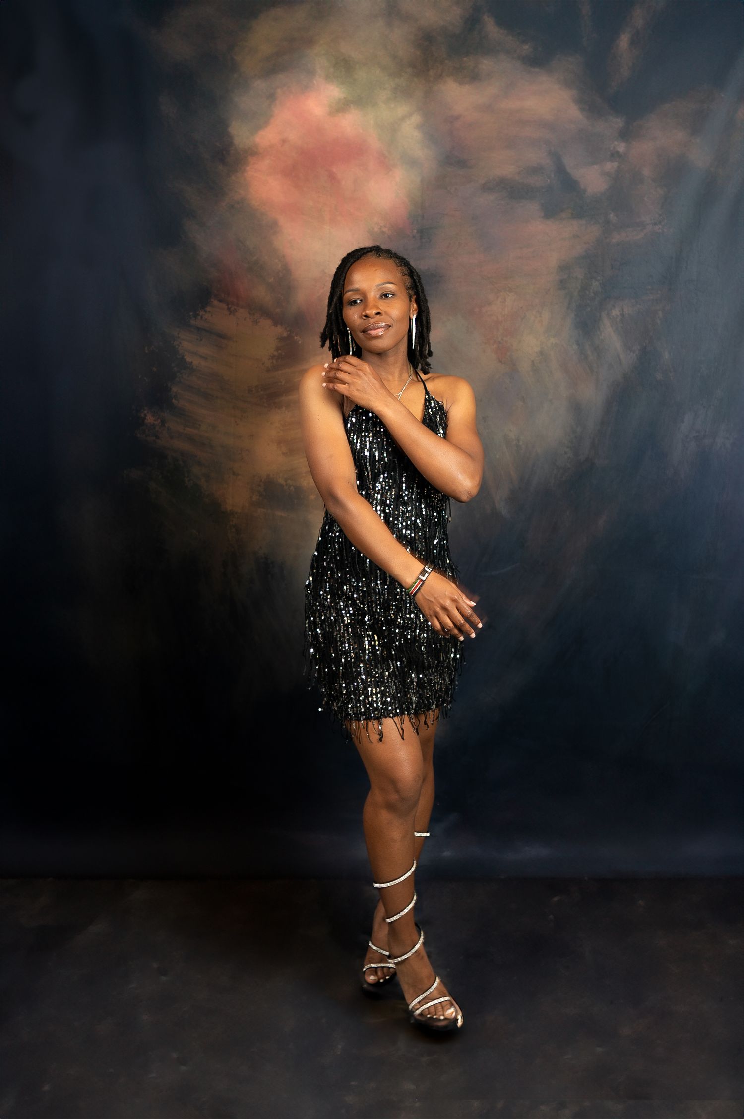 Full-length fashion portrait in shimmering black dress and strappy heels.