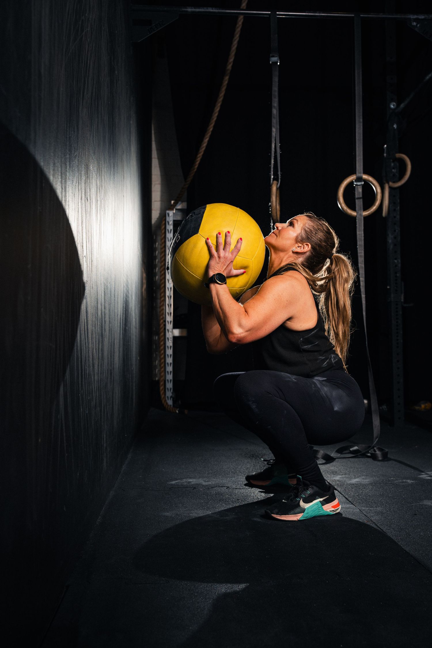 Fitnessfoto crossfit träning, kvinna som tränar med gul viktboll. Foto av Gabriel Alenius.