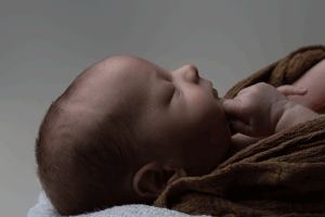 Side profile of a sleeping newborn during session with West Wales newborn photographer