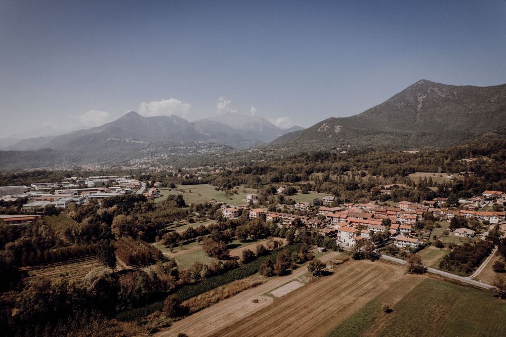 Aerial view of Italian countryside town nestled between mountains under blue sky.