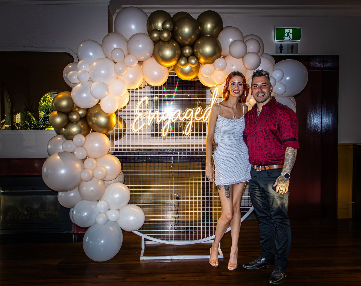 Decorative balloon arch with gold and white balloons framing an event display.