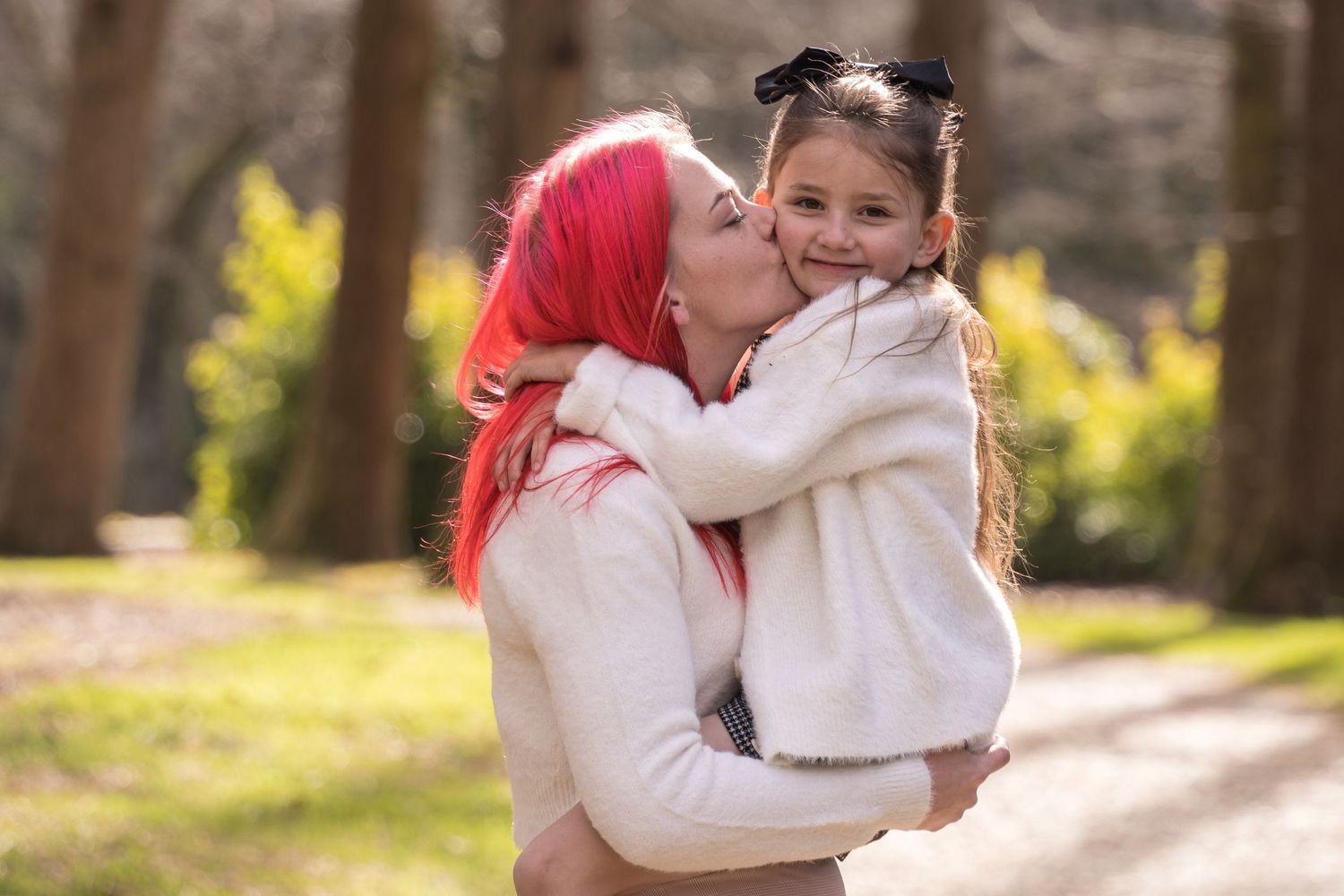 sister holding younger sister at park