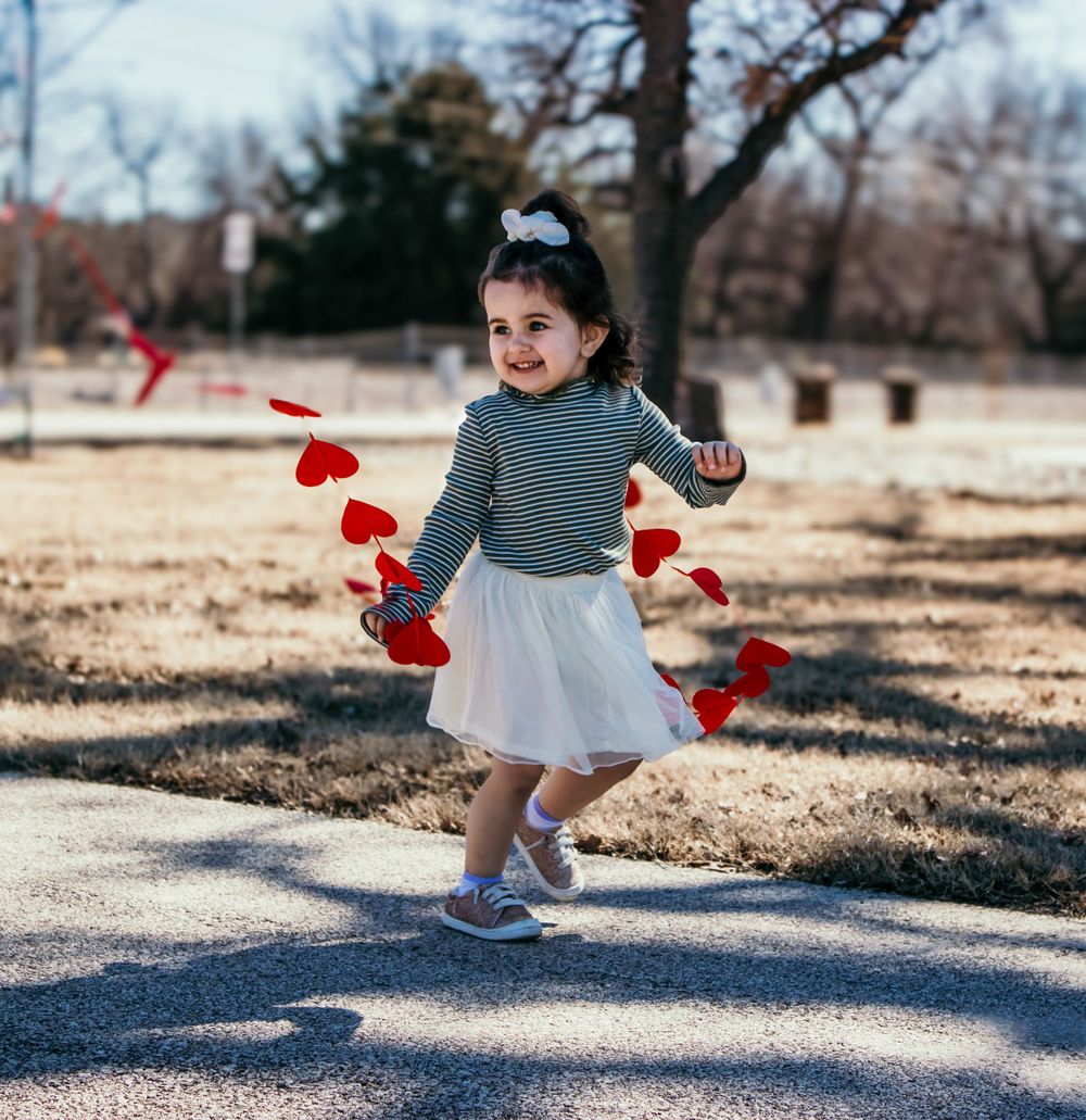 Dancing outdoors on a winter day with floating red paper hearts.