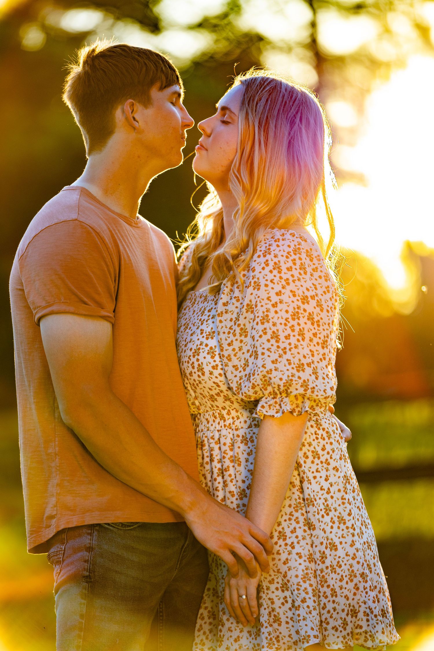 A romantic couple shares an intimate moment at sunset in a park setting. Geneva, Florida