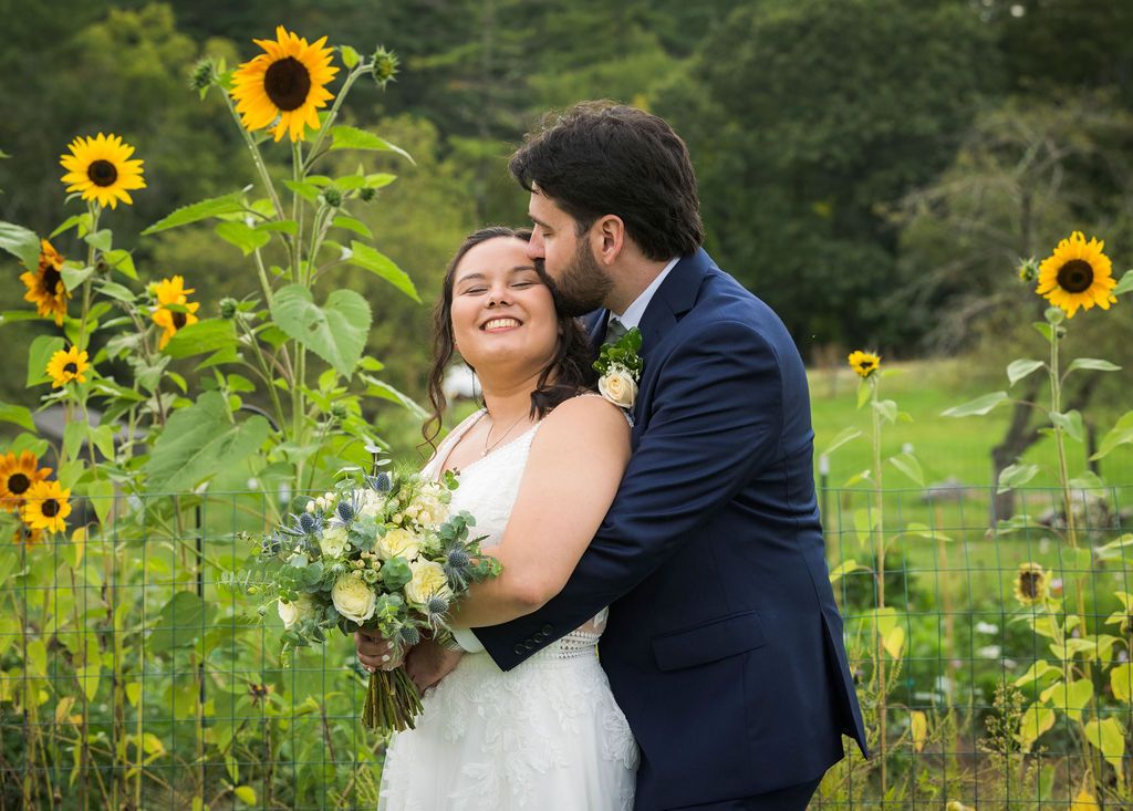 Couple shares romantic moments in a vibrant sunflower field during their wedding photoshoot.