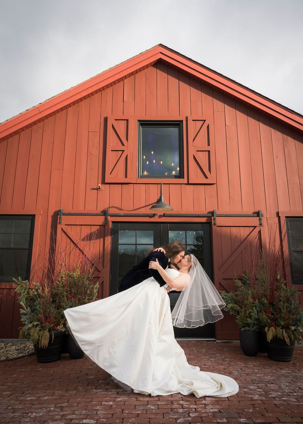 A sequence of wedding photos in front of a red barn showing a bride's dress flowing in dramatic poses.