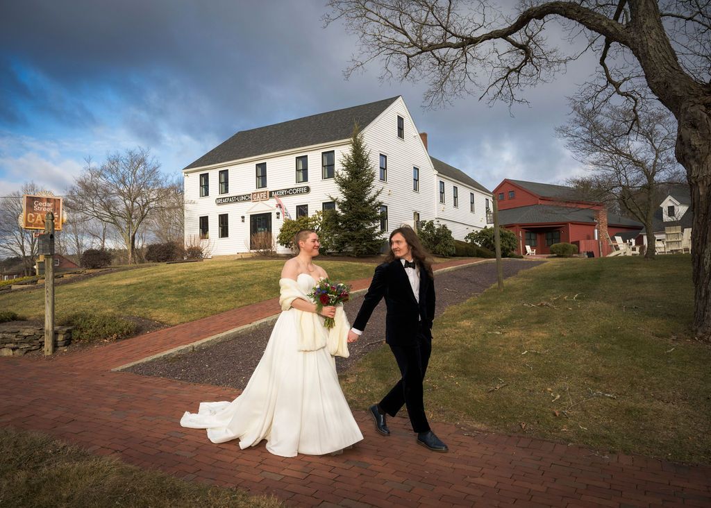 A series of wedding photos showing a couple walking on a rustic path with white buildings in the background.