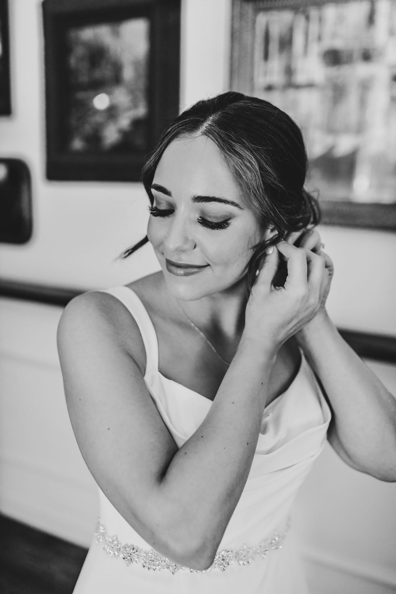 Bride candidly puts her earrings on before her wedding