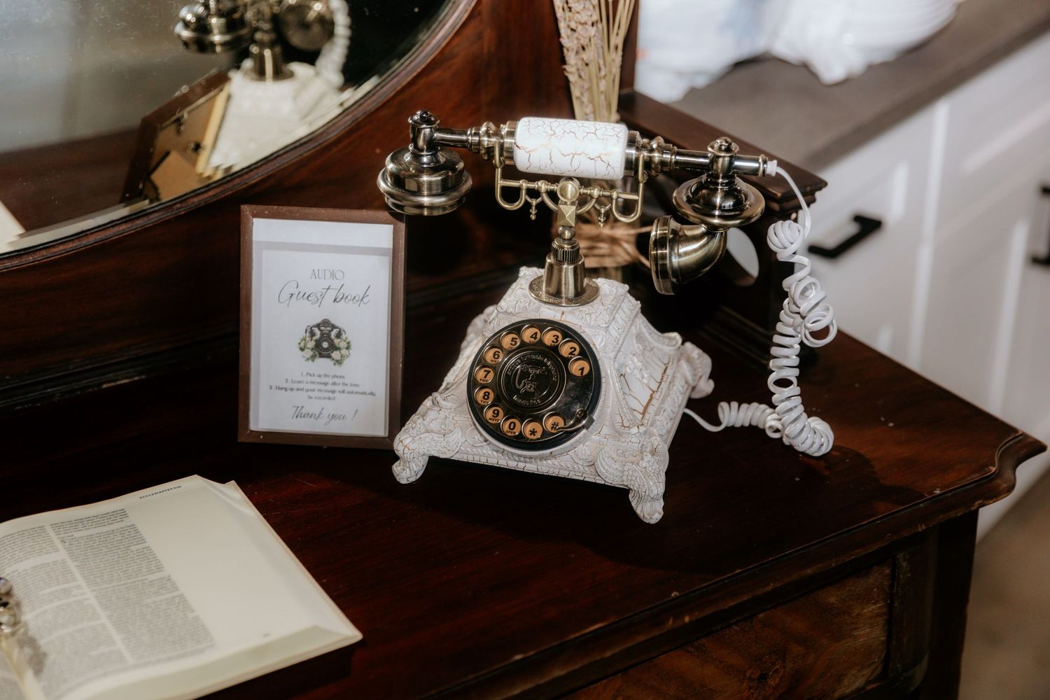 Vintage rotary telephone collection displayed on wooden surfaces with antique books and decorative elements.