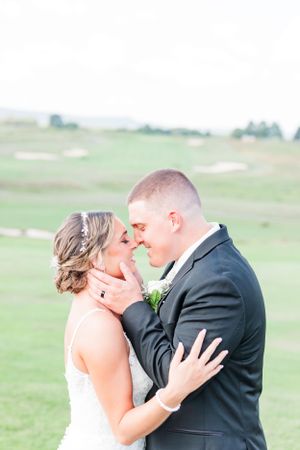 Intimate wedding portrait on golf course with soft, dreamy lighting.