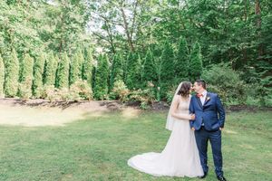 Romantic outdoor wedding ceremony in a lush green garden setting with natural landscaping.
