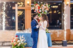 A romantic wedding moment captured in a sequence of photos with sparklers glowing against a brick building backdrop.