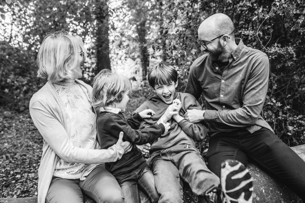 Happy family with two children laughing together outdoors in a wooded park setting. Potlick Forest, Westmeath