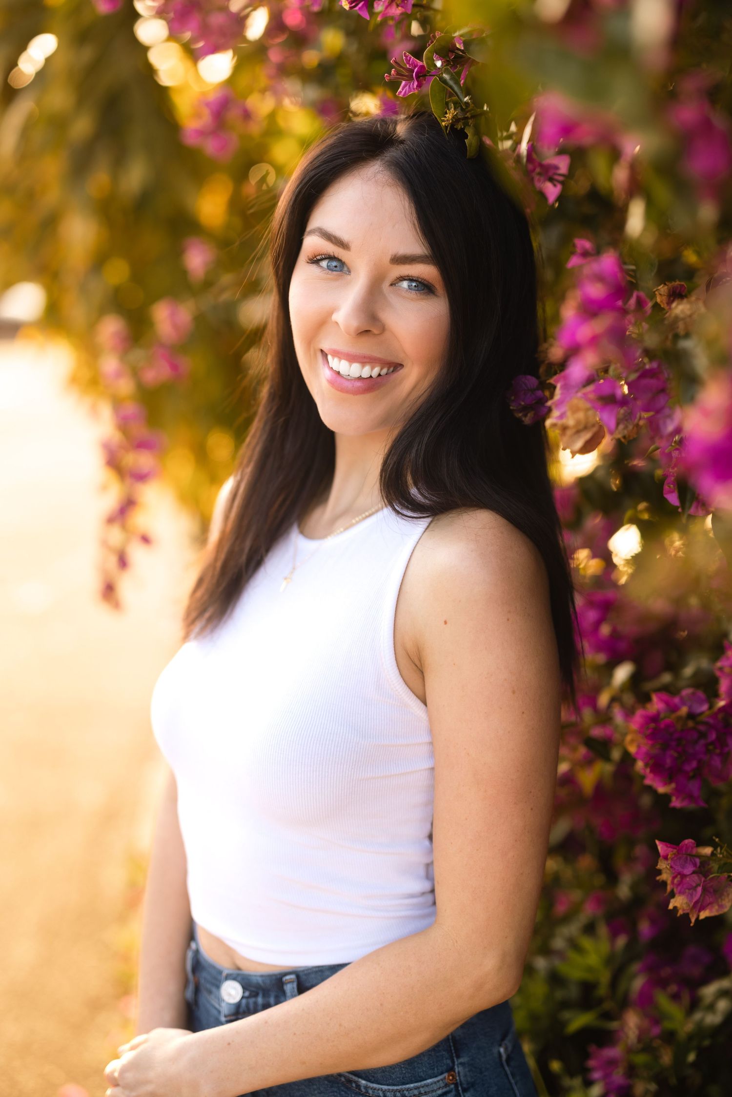 Portrait against pink bougainvillea flowers in warm sunset lighting.