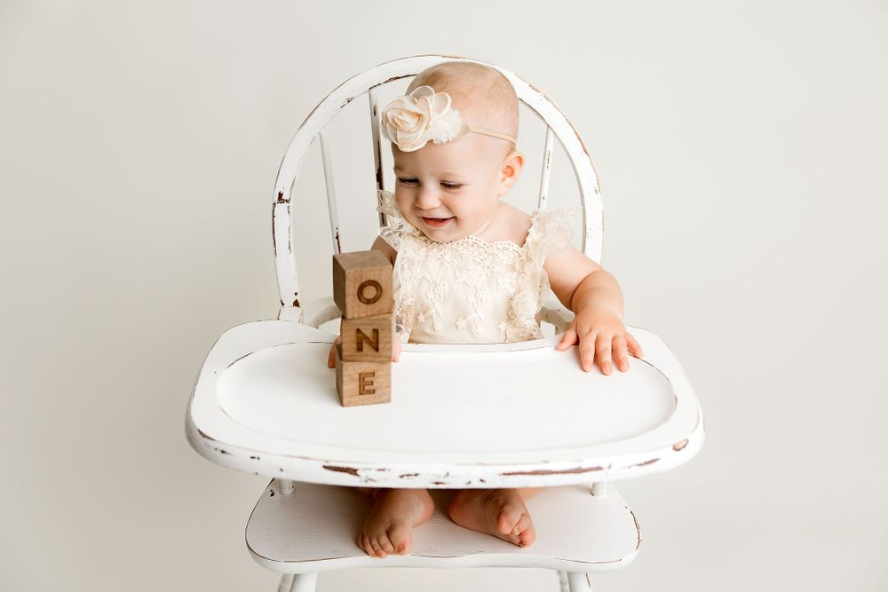 First Birthday Baby girls in vintage High Chair playing with ONE blocks