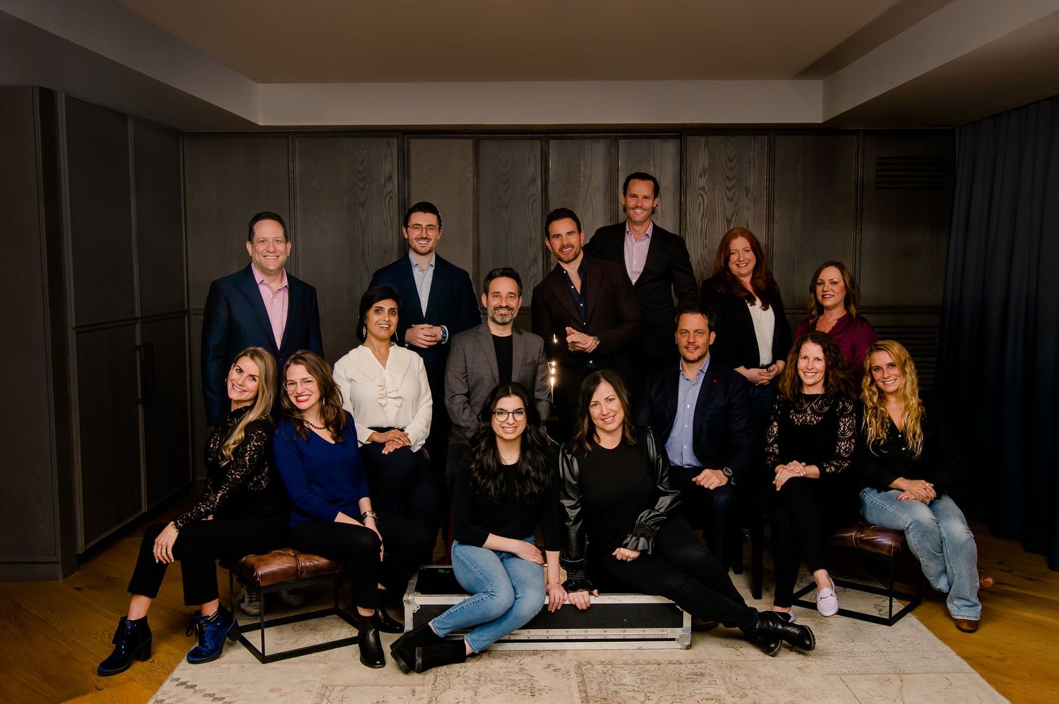 A group of company team members sitting in a casual formation for a corporate photo shoot.