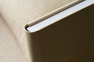 Close-up view of a cream colored textile surface with dramatic lighting and shadows.