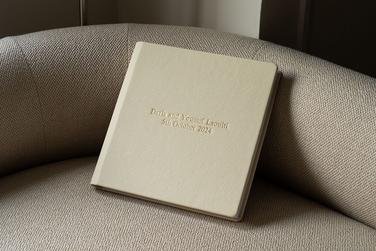White business cards arranged in a minimalist composition on a beige textured surface showcasing elegant design.