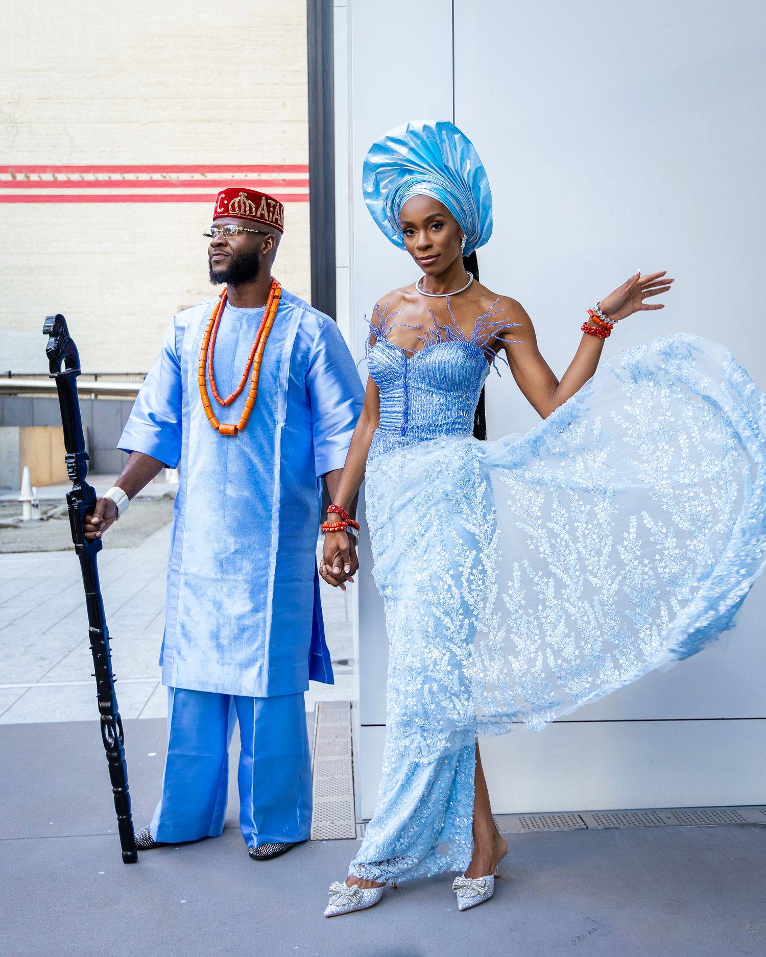 A fashion photoshoot featuring elegant blue traditional African attire with flowing fabric in a modern studio setting.
