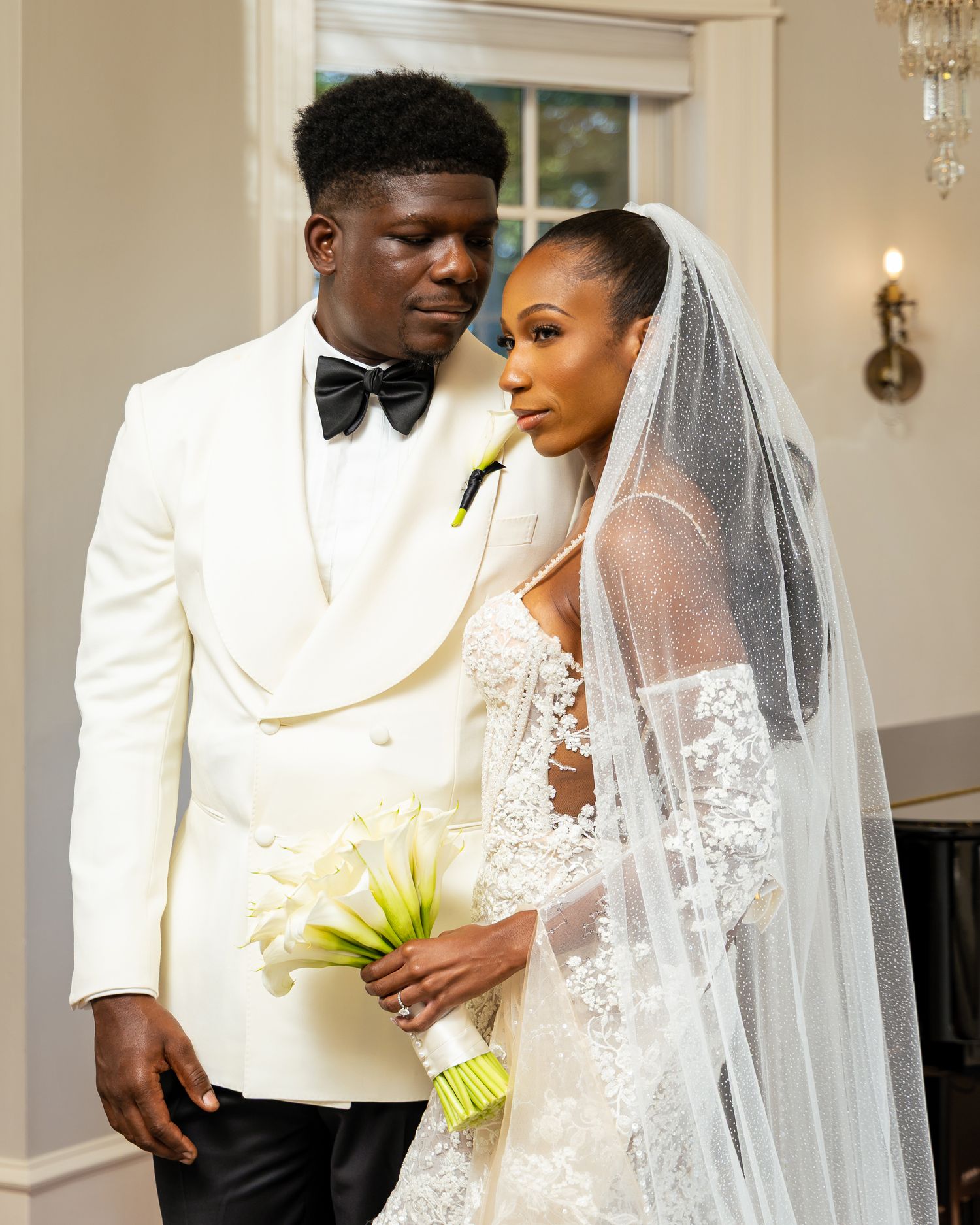 A bride and groom share intimate moments during their wedding ceremony in an elegant indoor venue.