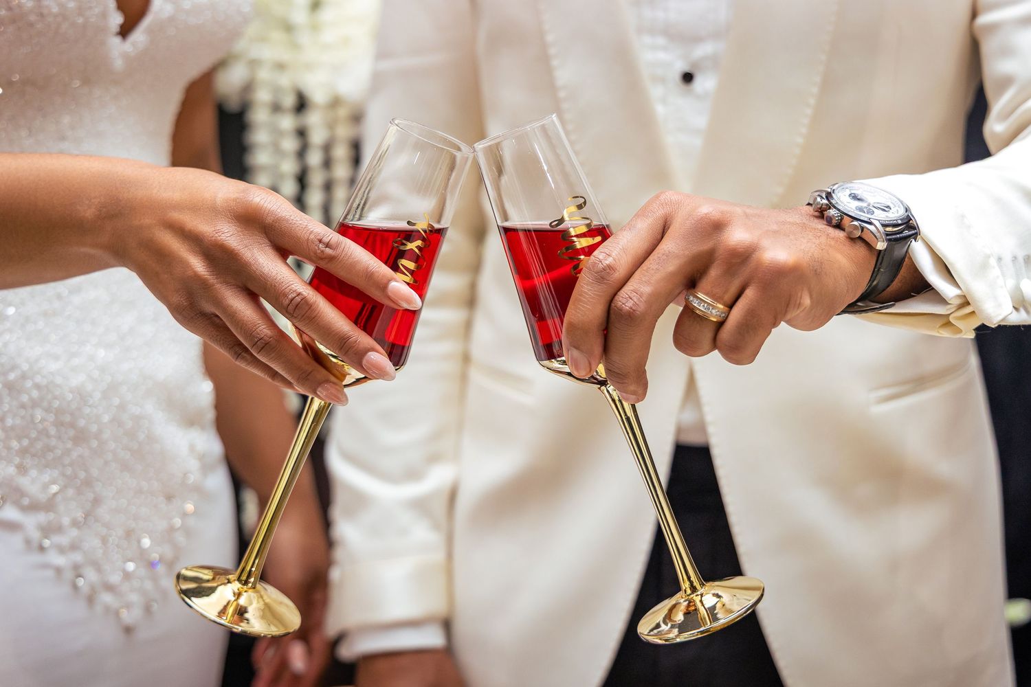 Wedding guests holding champagne glasses in elegant formal attire during a celebratory toast.
