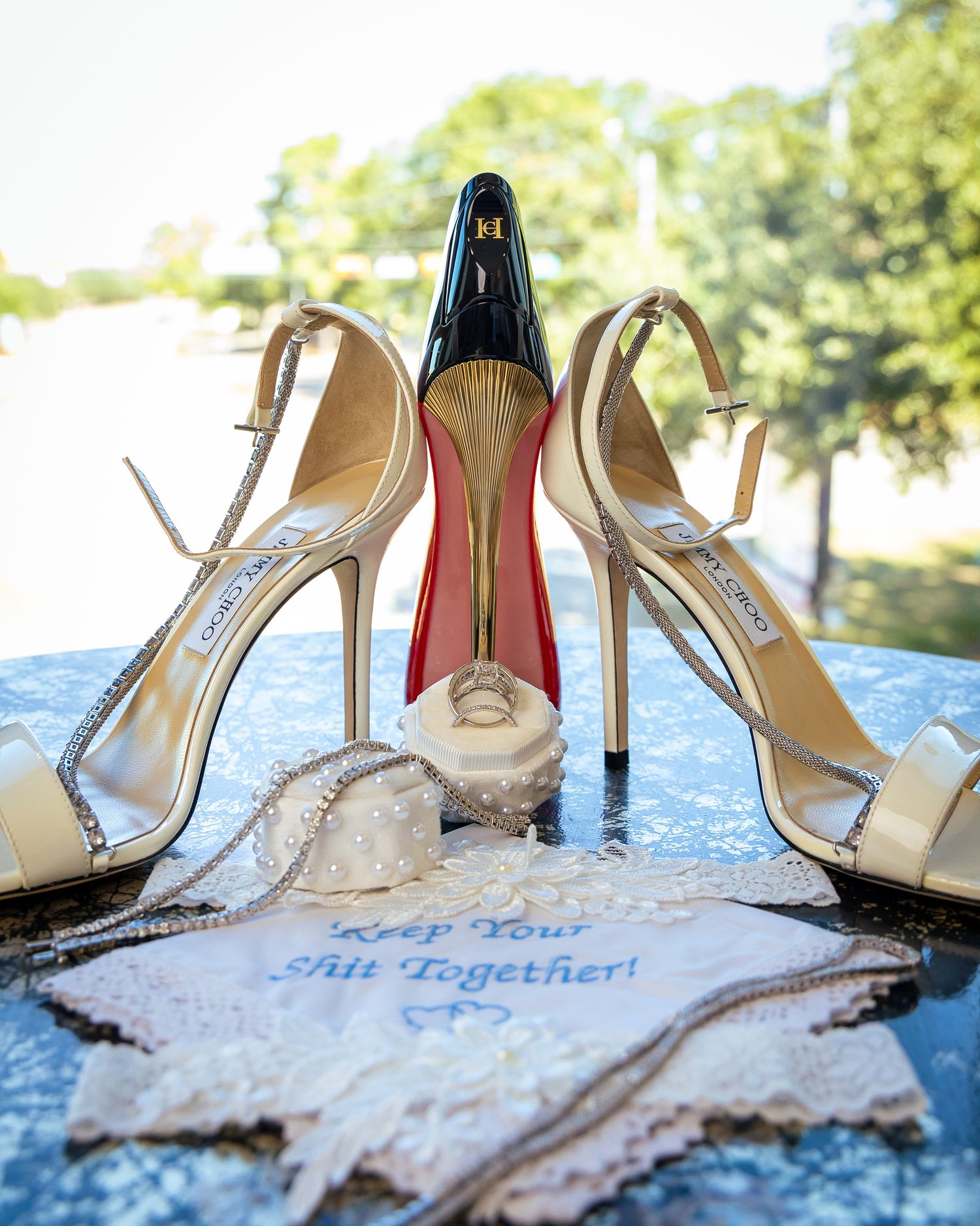 White bridal shoes with lace detailing arranged artistically on a light blue textured surface with text in the background.
