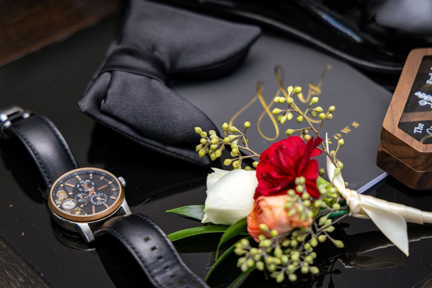 A luxury watch collection displayed with elegant red roses and delicate white flowers against a dark background.