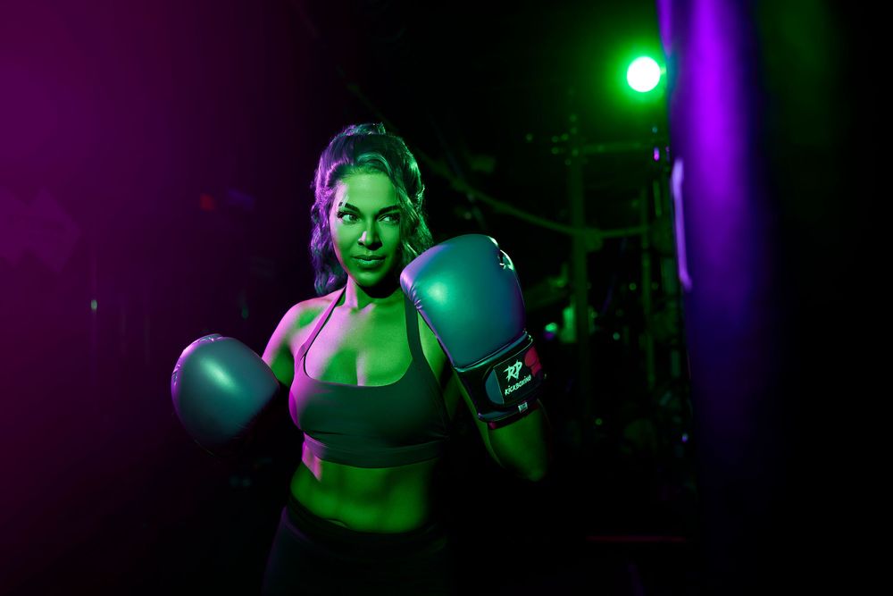 A person performs on stage with dramatic green and purple lighting effects creating a theatrical atmosphere.