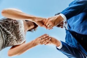 Creative aerial view of hands reaching across blue sky background. Middle TN wedding photographer.