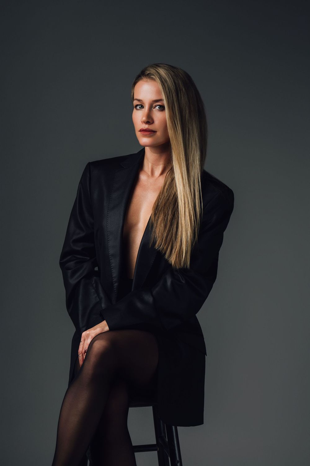 Minimalist fashion shoot featuring black blazer and dramatic lighting.