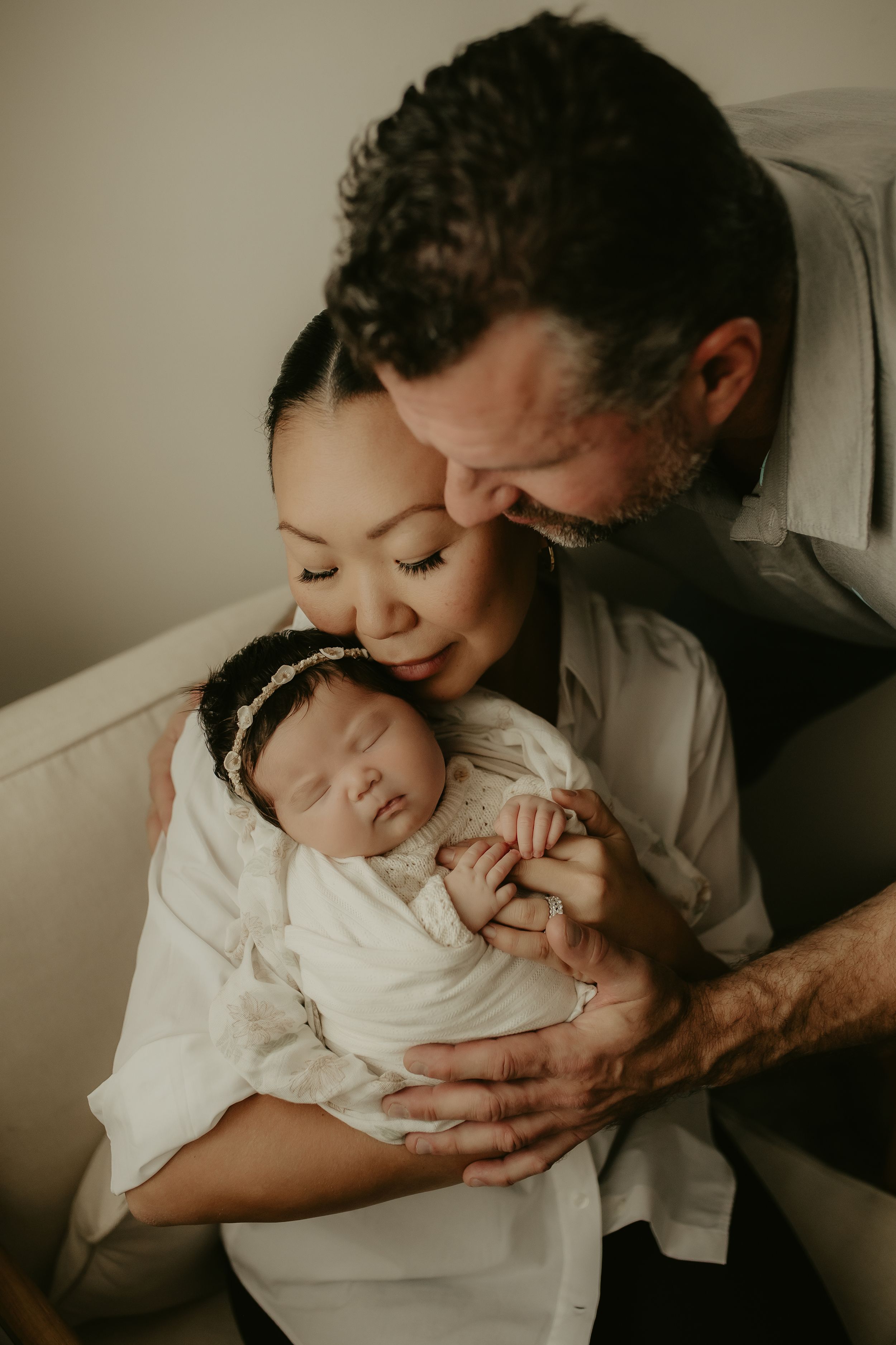 A tender moment between parent and newborn baby shown in a series of intimate black and white photographs.