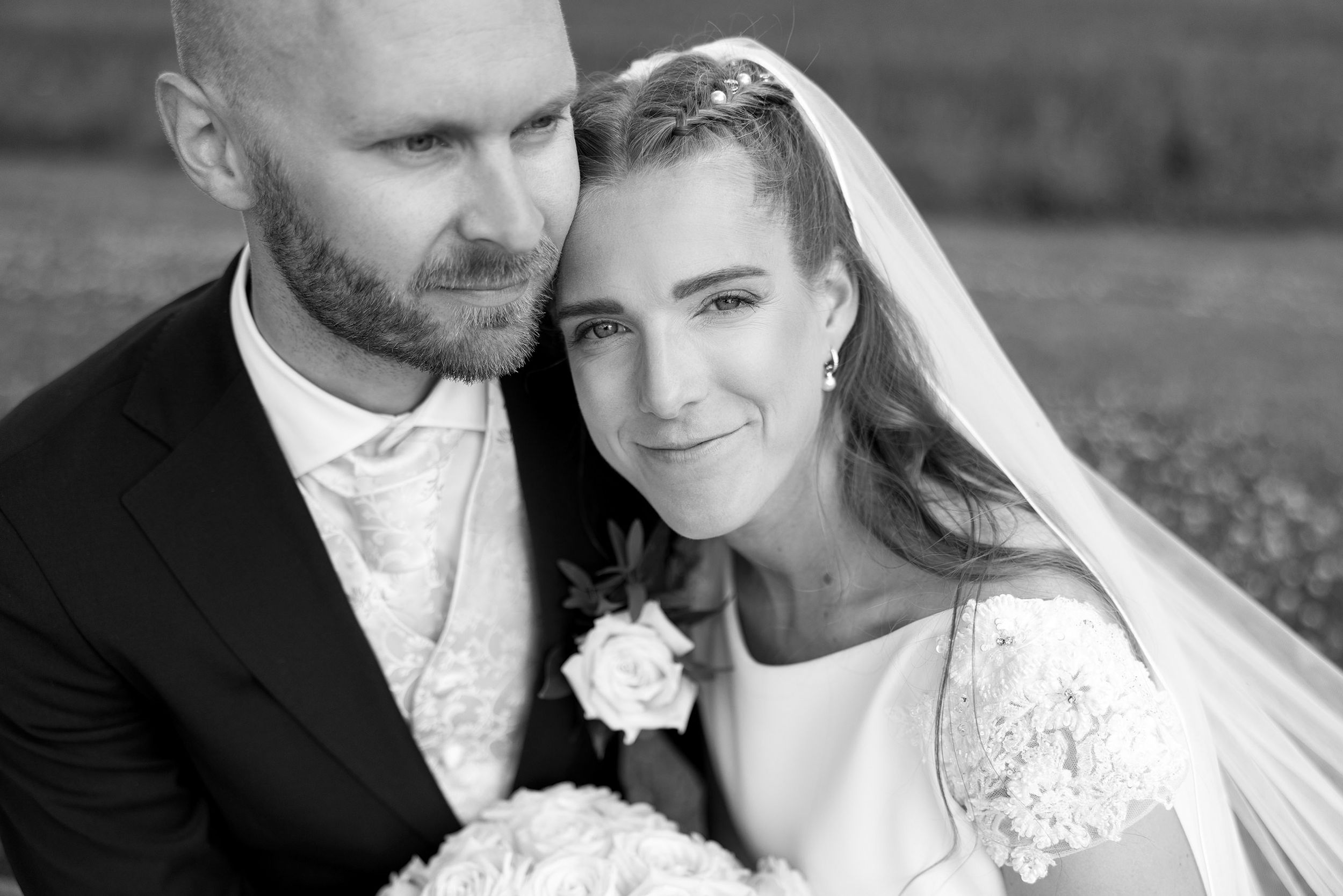 Bruden som lener seg på brudgommens skulder. Hun gir et uttrykk som utstråler både ro og trygghet