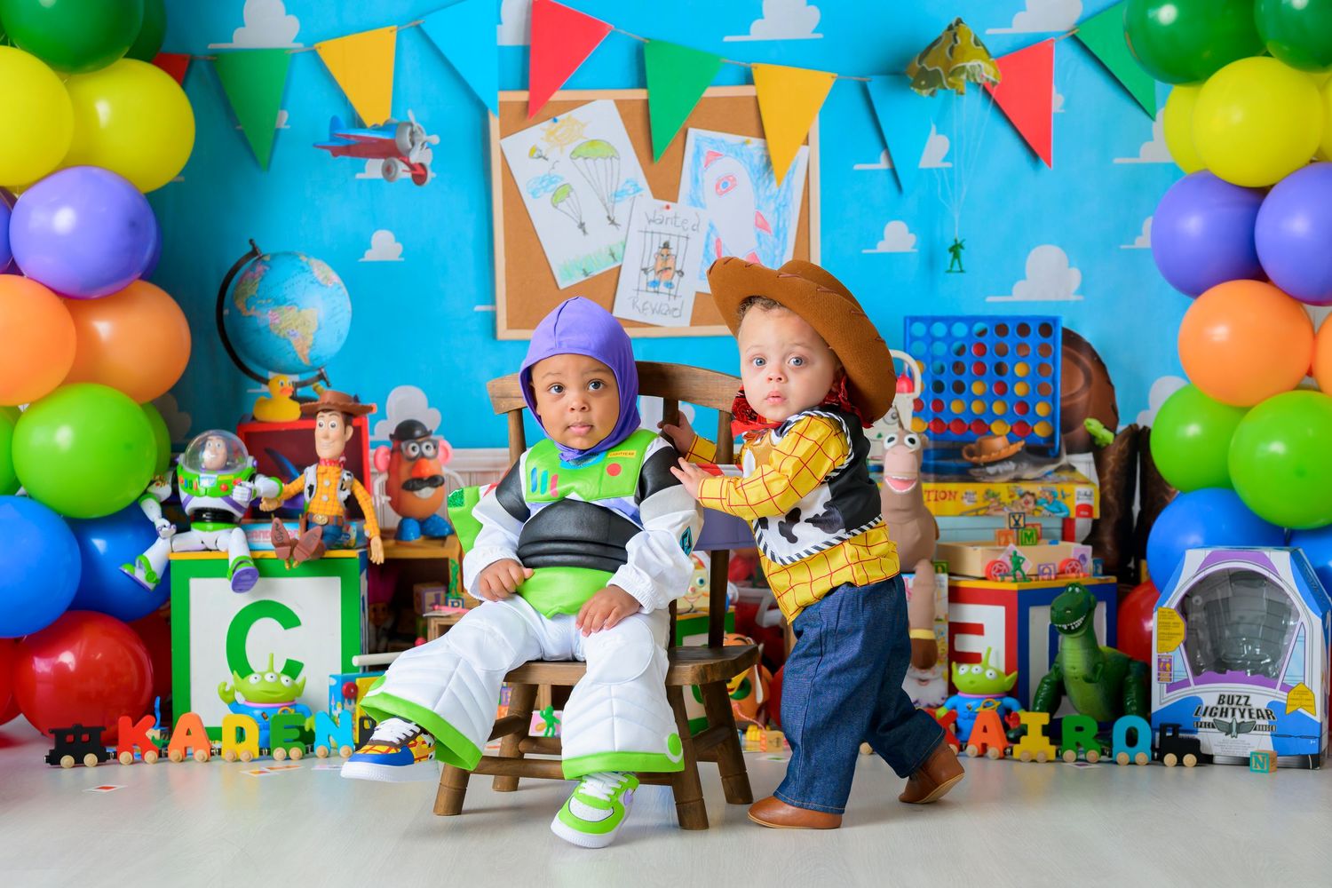 Colorful toy figures and balloons arranged in a festive party display with bright decorations and party supplies.
