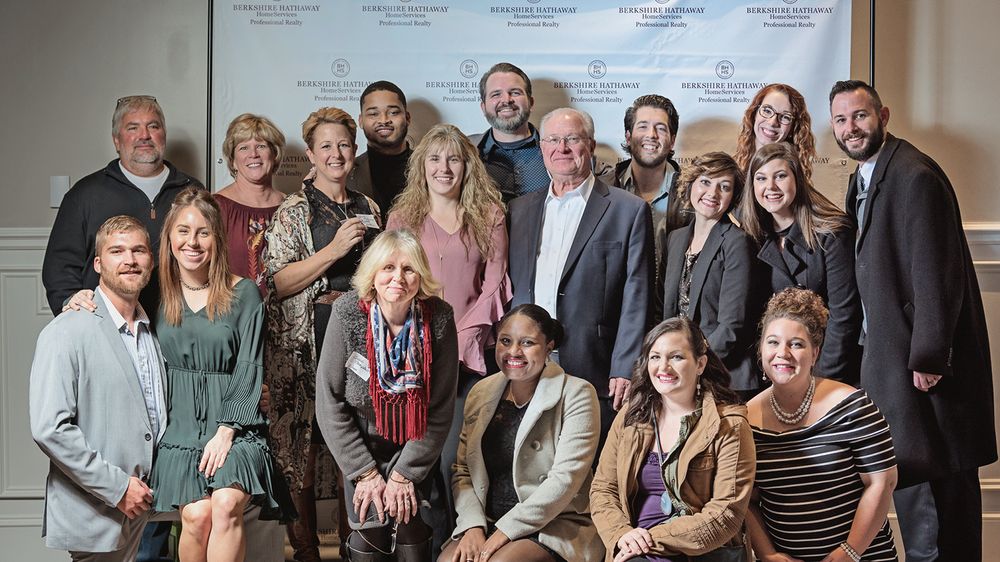 Large group photo of event attendees posing together in a formal setting.