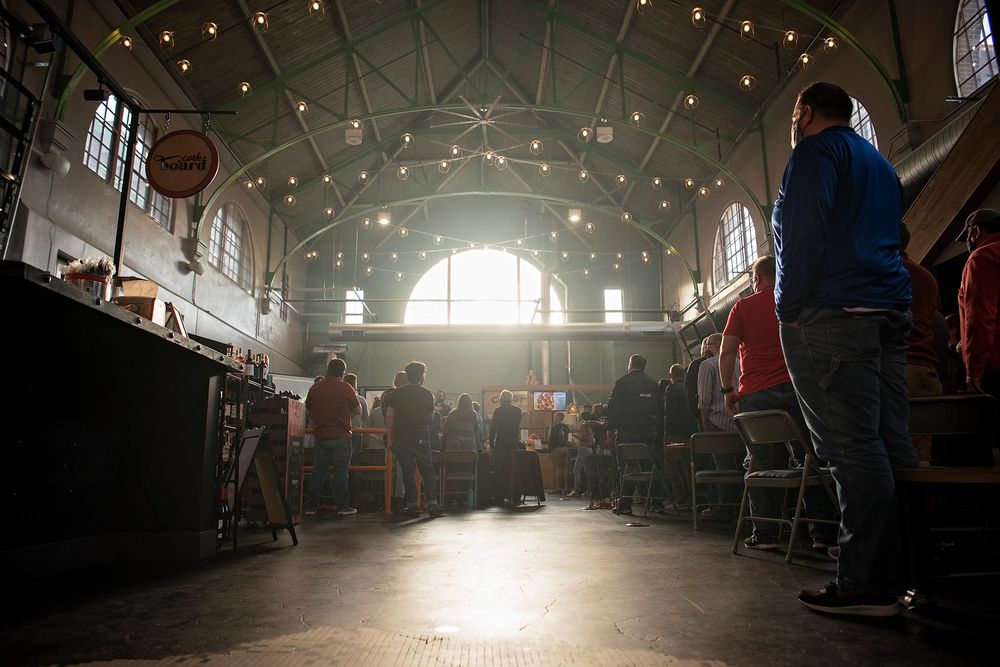 Interior of historic venue with hanging lights and natural sunbeams streaming through windows.