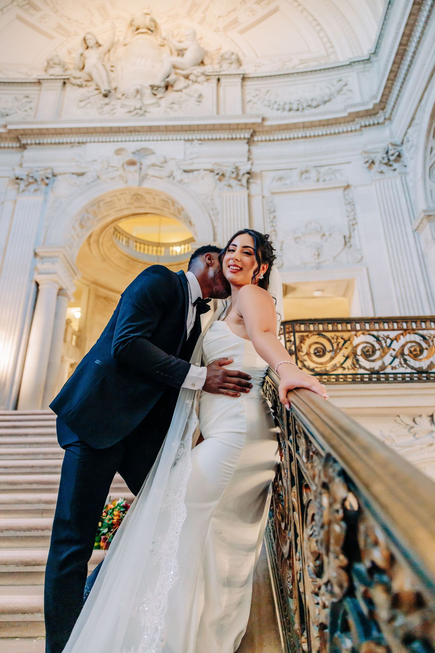 Newlyweds share intimate moment at outdoor wedding reception table with soft bokeh effect in San Francisco City Hall
