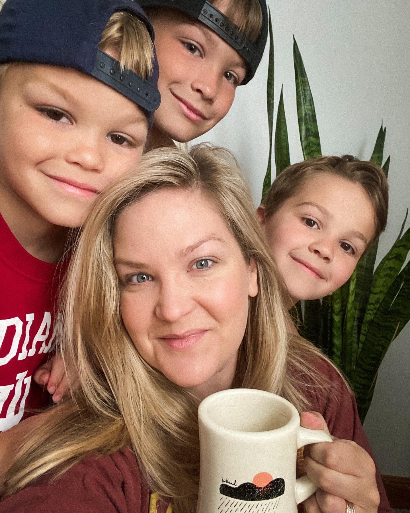 A cozy selfie moment showing of local NWI wedding photographer gathering around a coffee mug with a houseplant in the background.
