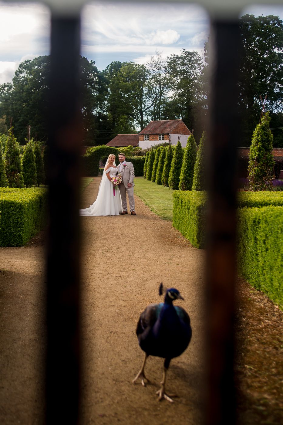 Wedding venue garden path lined with tall cypress trees and gravel walkway.