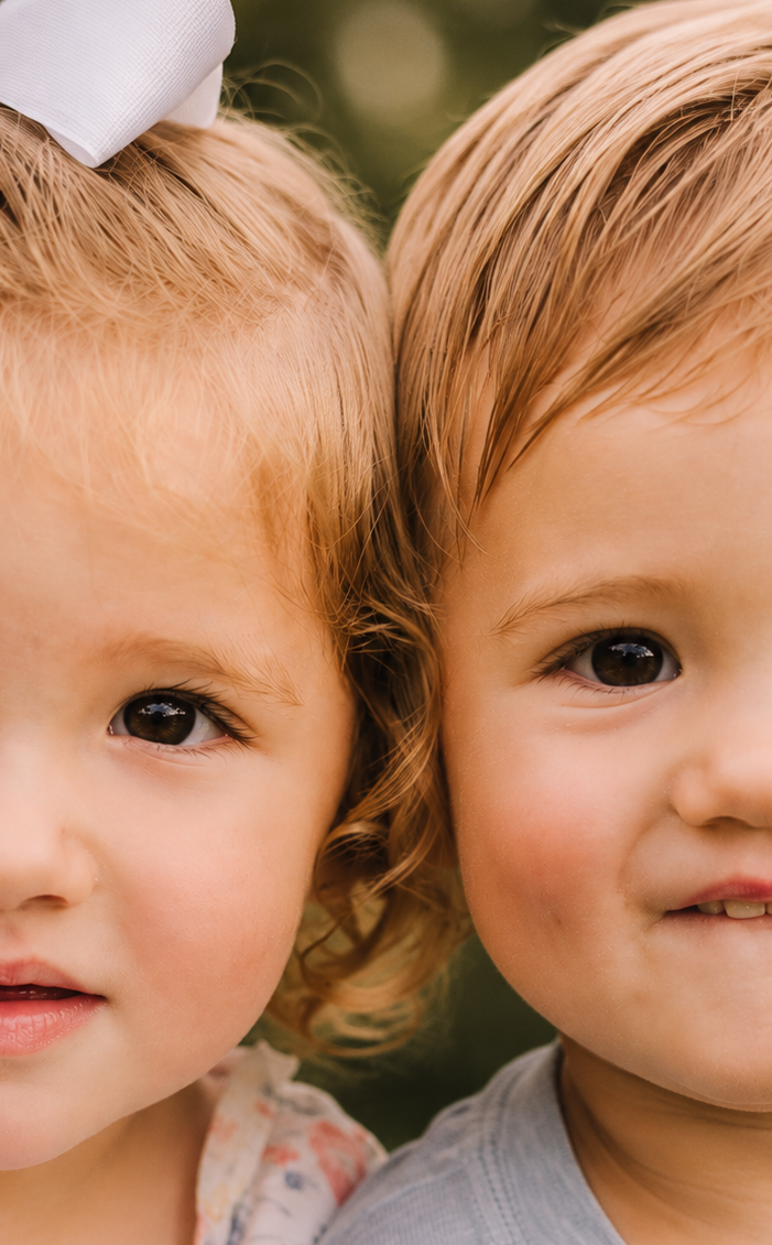 Two adorable twin toddlers with blonde hair posing cheek to cheek for littles milestone photoshoot in Cheatham county tn