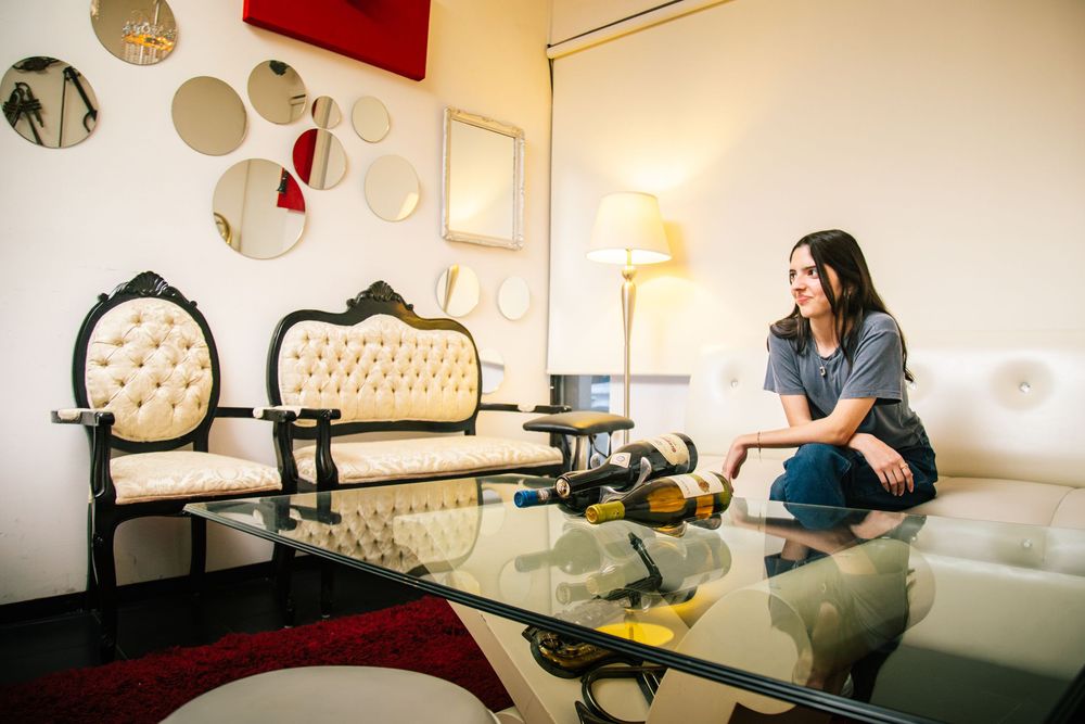 A sequence of images showing a person lounging on a white couch in a modern living room setting.