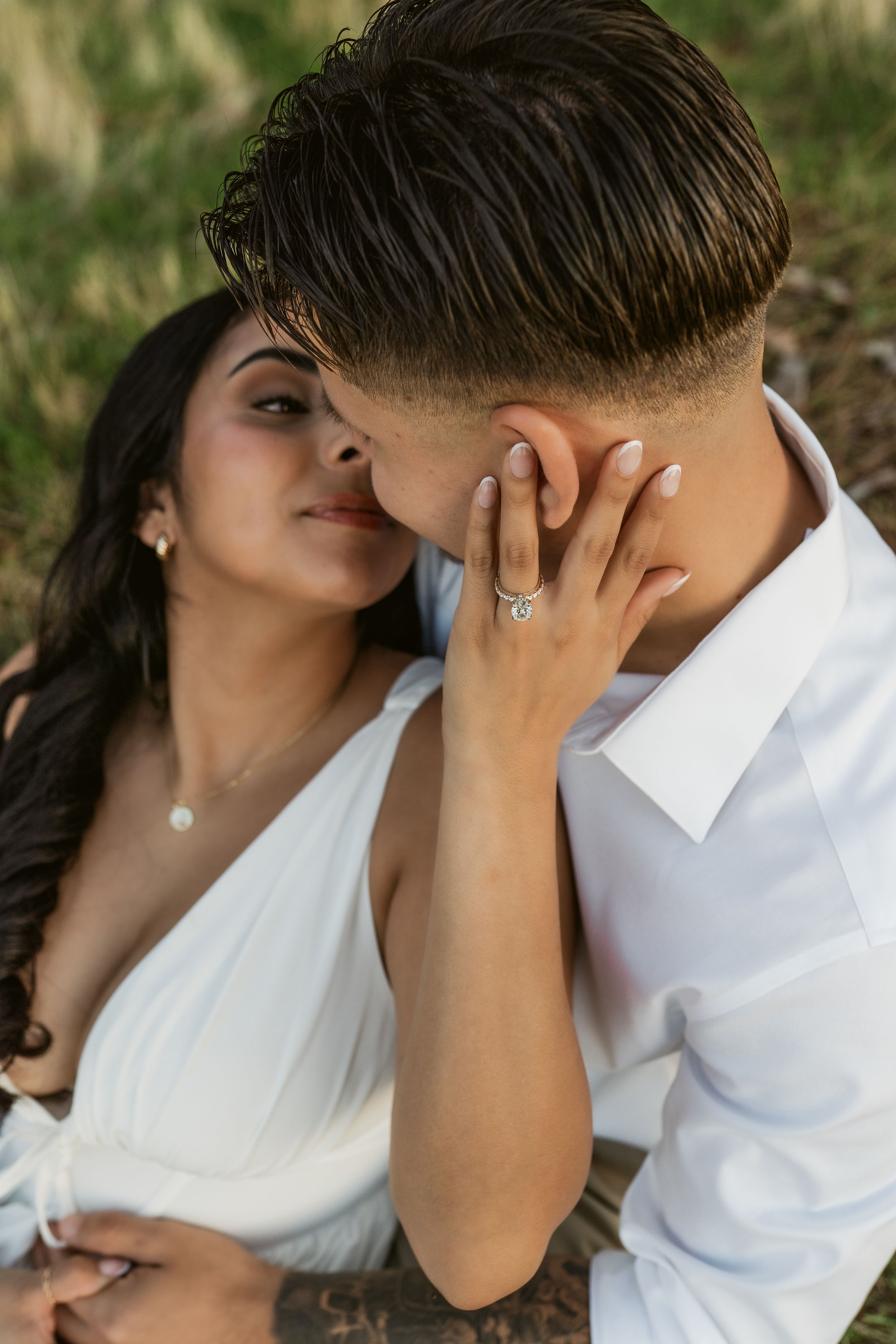 A romantic sequence of close-up shots showing a tender kiss between a couple against a natural outdoor background.