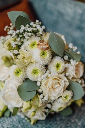 Hochzeitsstrauß aus weißen Rosen und Babyatem mit Eukalyptusblättern und Eheringen.