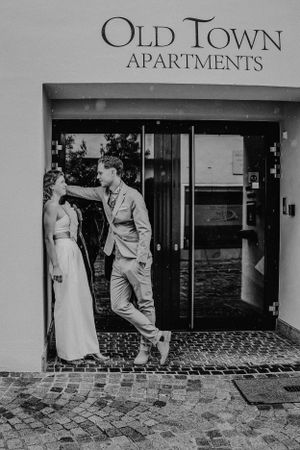 Ein Paar posiert vor dem Eingang der Old Town Apartments in Schwarz-Weiß-Fotografie.