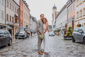 Ein Paar, das zusammen auf einer charmanten Kopfsteinpflasterstraße mit historischer europäischer Architektur steht. Kaufbeuren