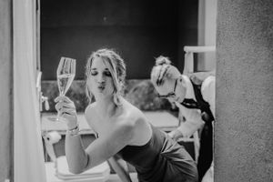 Ein Schwarz-Weiß-Porträt von jemandem, der ein Champagnerglas zur Feier hält.