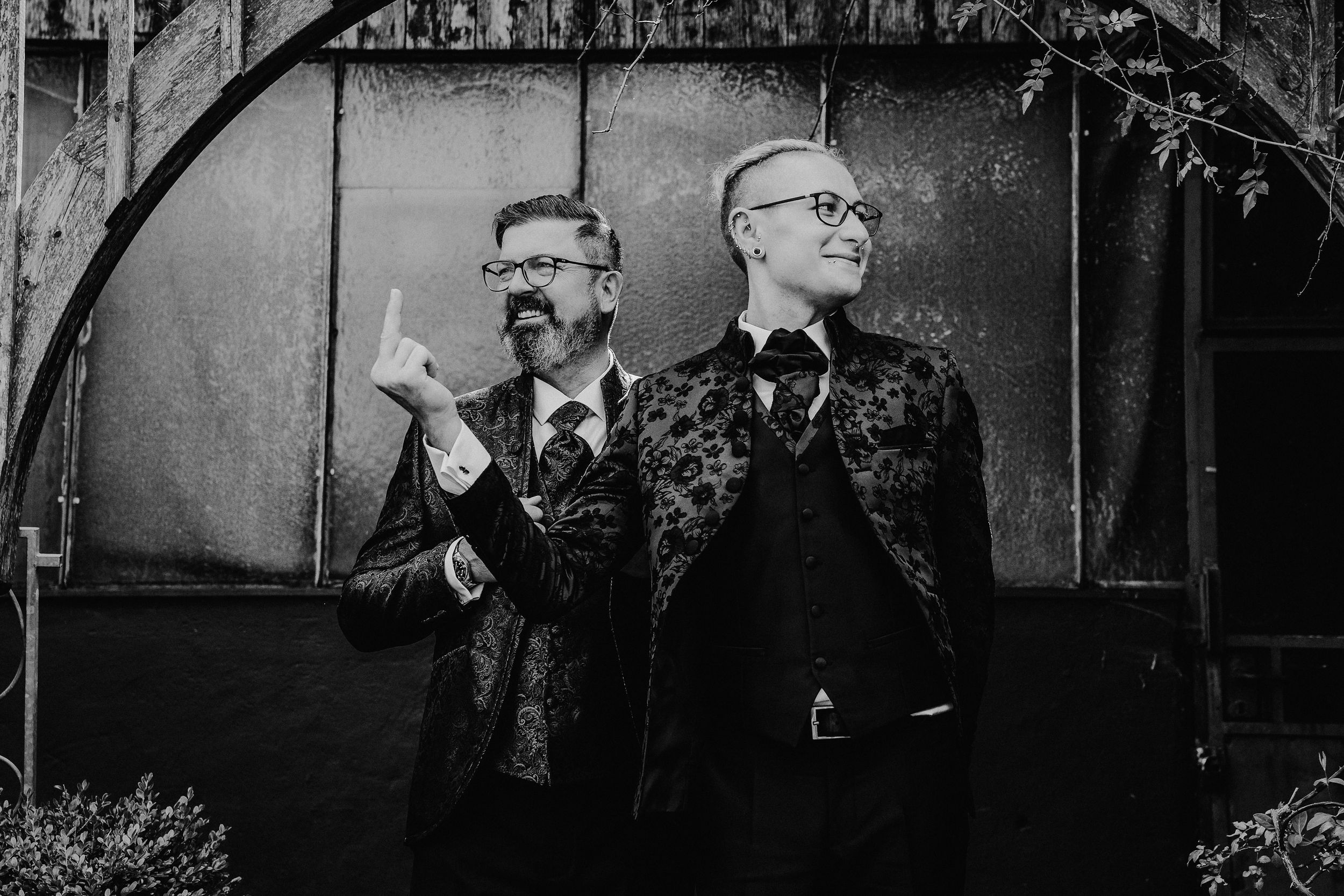 Ein Homosexuelles Hochzeitspaar posiert spielerisch auf einem Schwarz-Weiß-Foto.