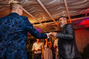 Ein Homosexuelles Hochzeitspaar tanzt zusammen an einem Empfang unter bunter Stimmungsbeleuchtung.