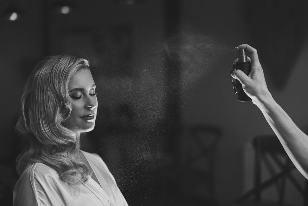 Artistic black and white photo showing perfume being sprayed in soft lighting. Mill Barns