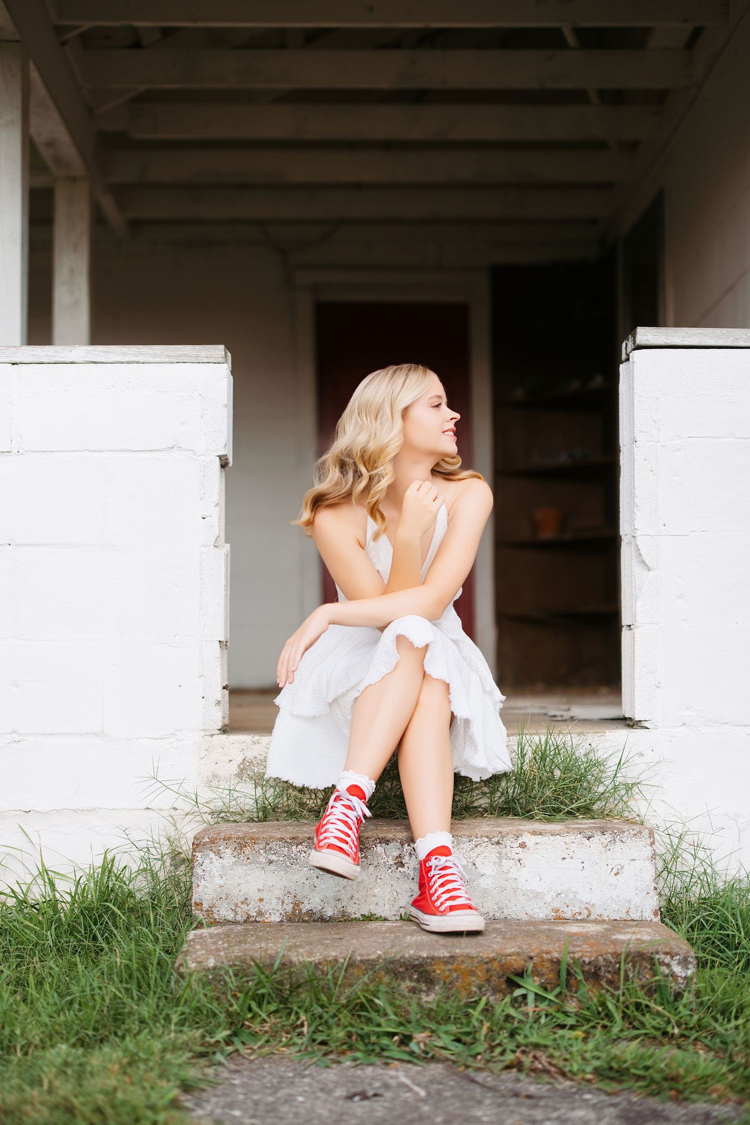 Casual portrait series sitting on concrete steps wearing red sneakers. Middle TN senior photographer.
