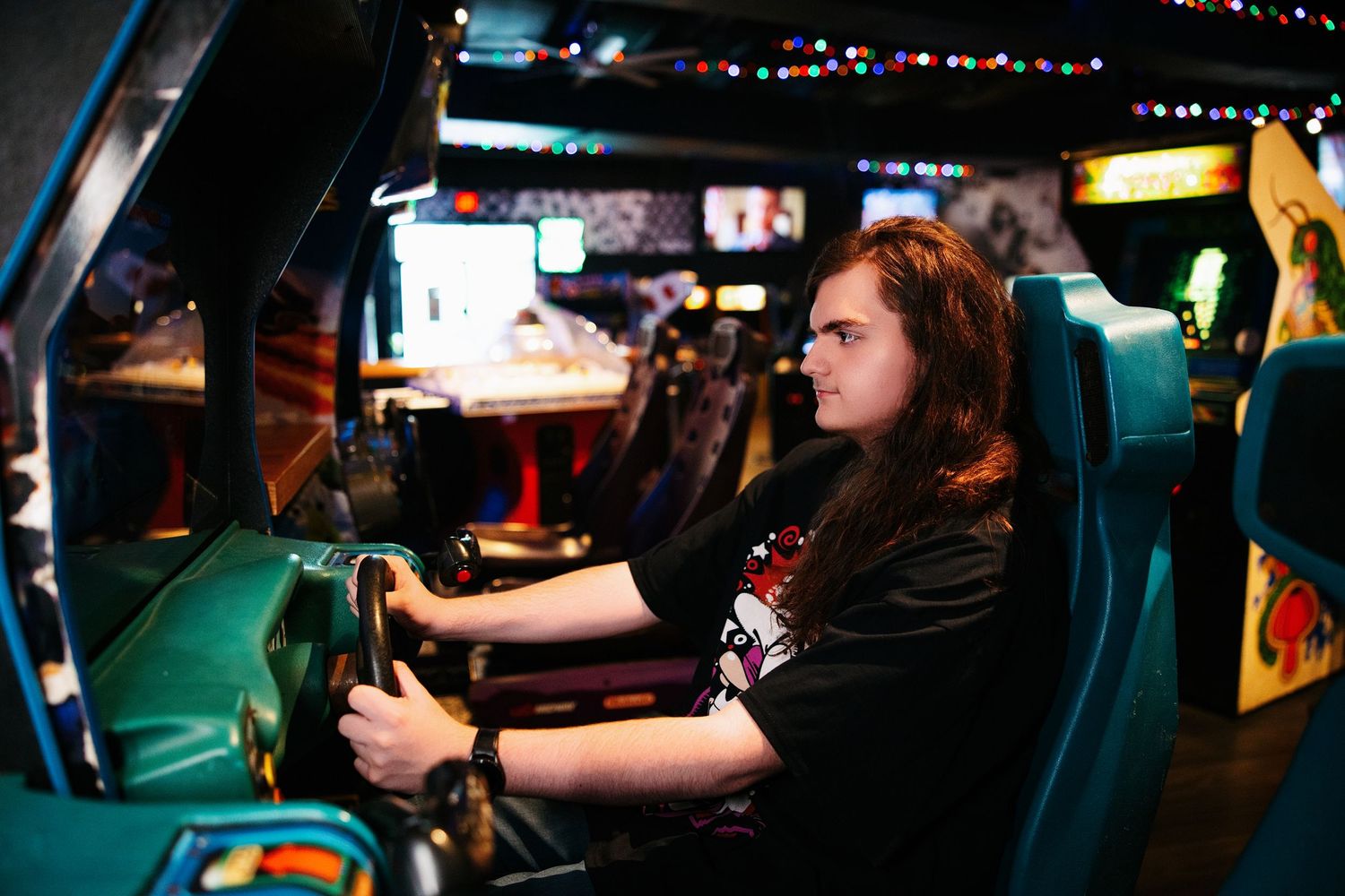 A group of gamers playing video games at an esports tournament with monitors and gaming equipment visible.